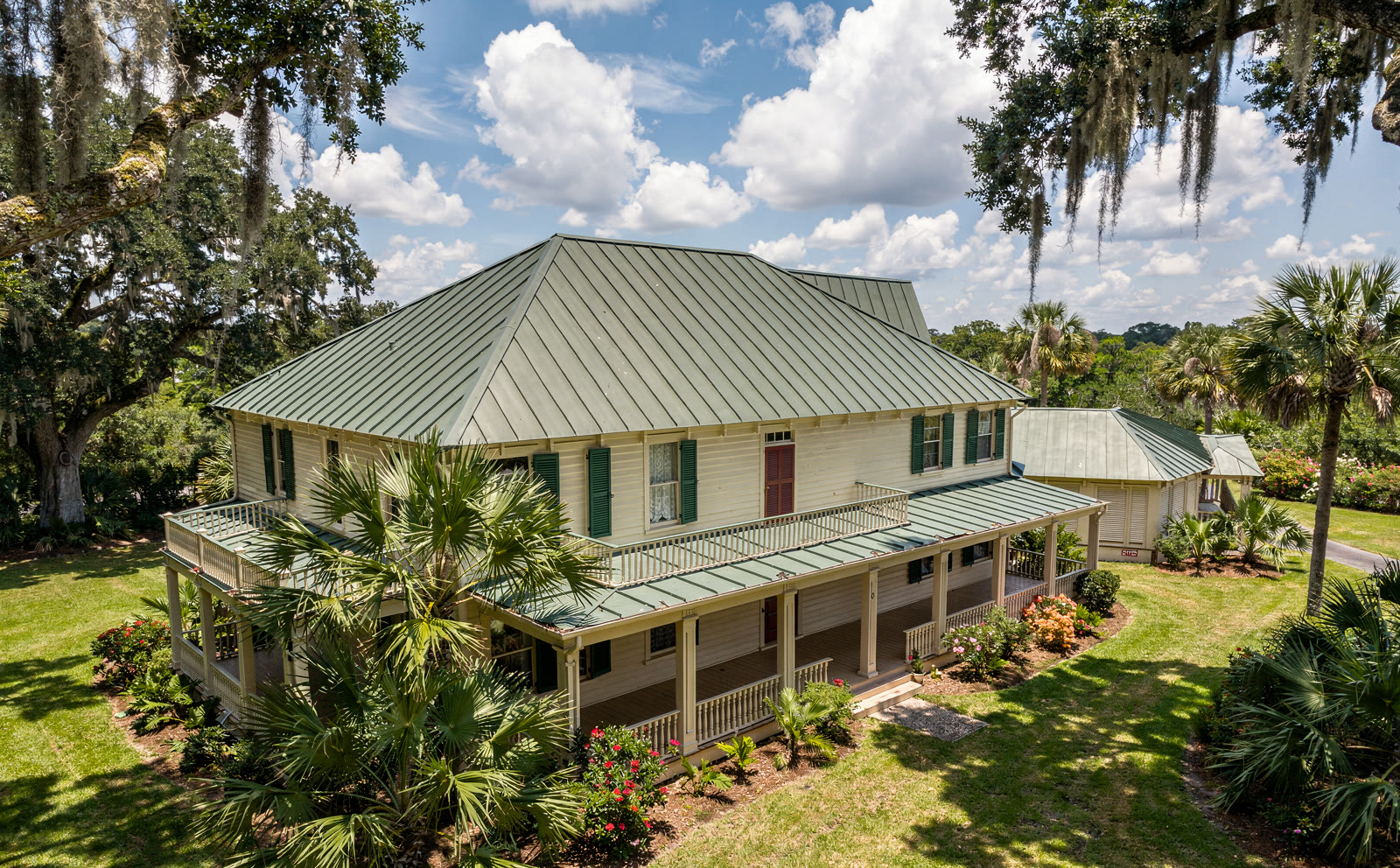 Aerial photograph of the house from above and to the
      south west, the gazebo in the near corner, the main hipped roof beyond it and the wing running away to the
      far side.