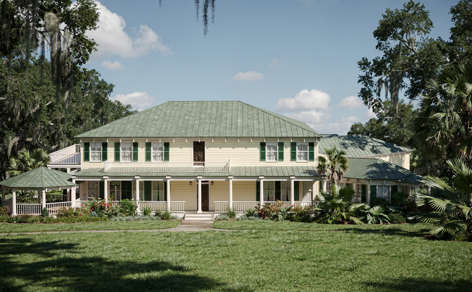 The house photographed from the south: cream
      clapboard, green metal hipped roof, full width porch on turned posts, gazebo at the left